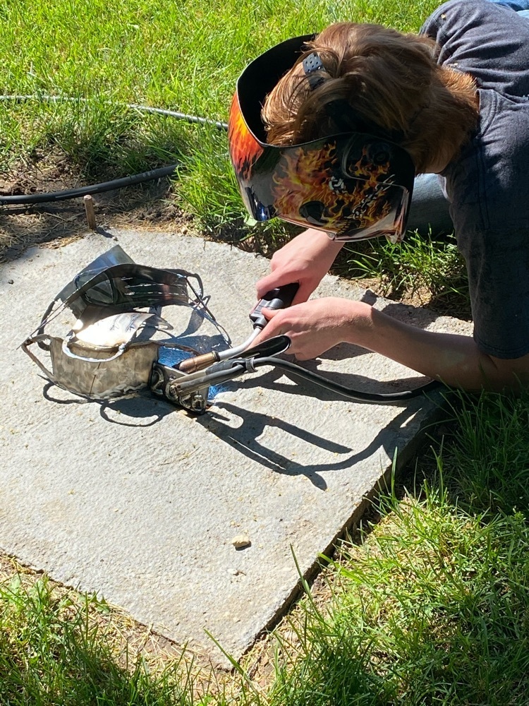 Owon welding the commemorative 2020 sculpture.